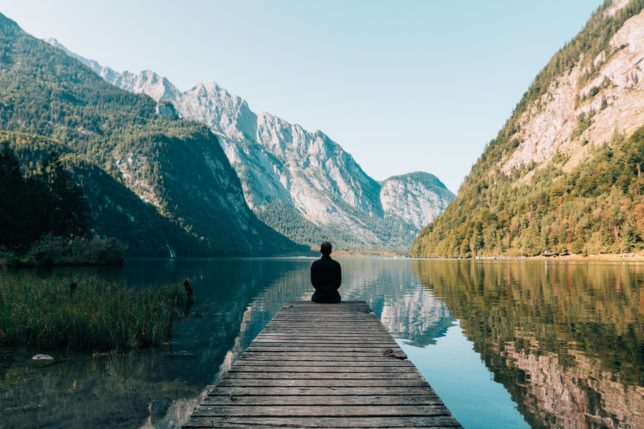 person on a bridge near a lake